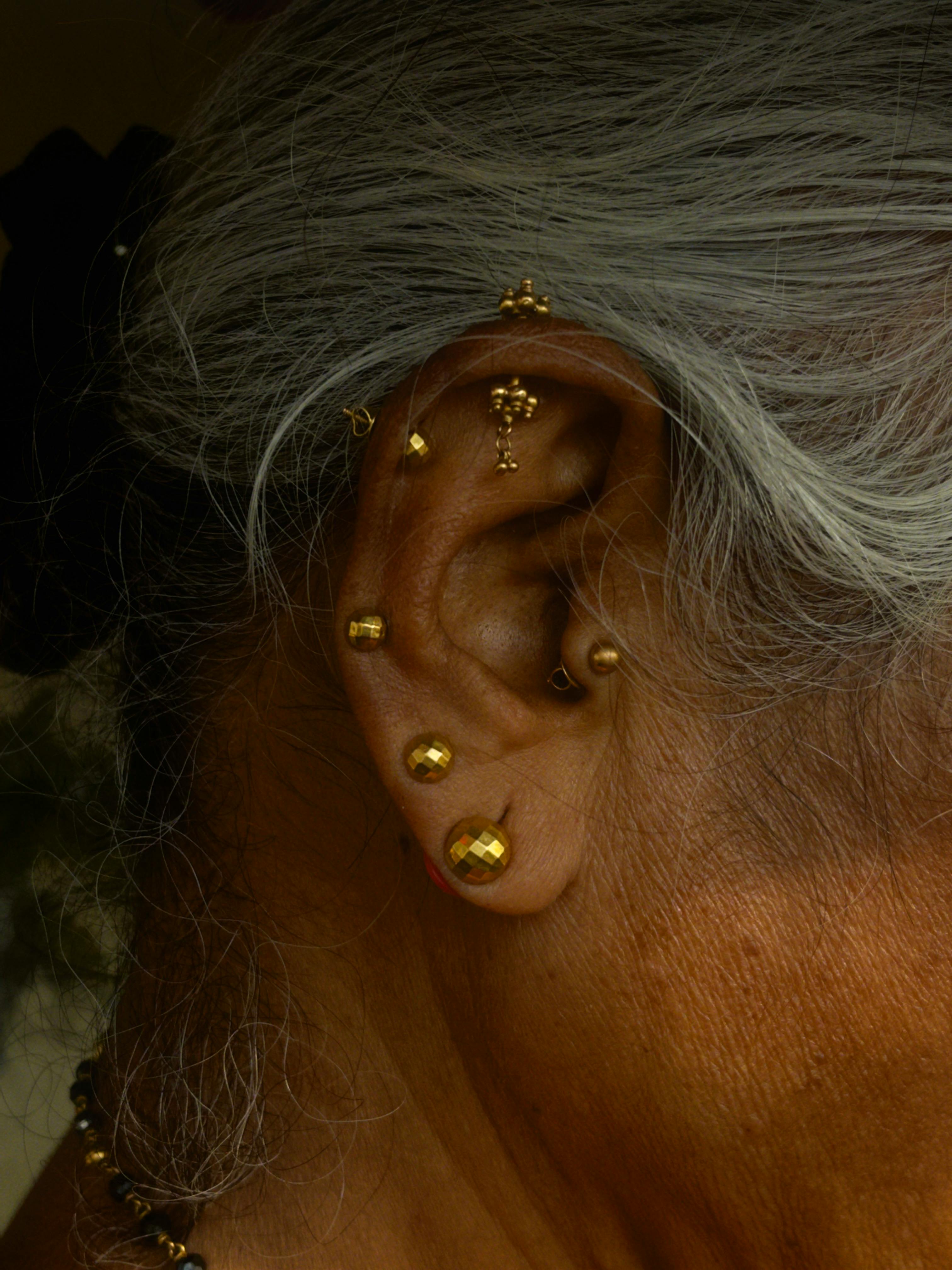 Photo by Bhumika: https://www.pexels.com/photo/close-up-of-elderly-woman-s-ear-with-gold-earrings-32275806/